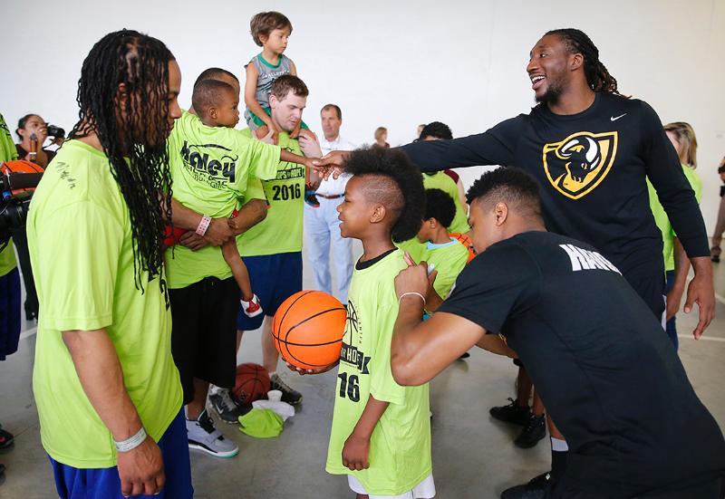 Torey Burston and Mo Alie-Cox greet fathers and sons during a break on the basketball court at the Richmond City Justice Center.
