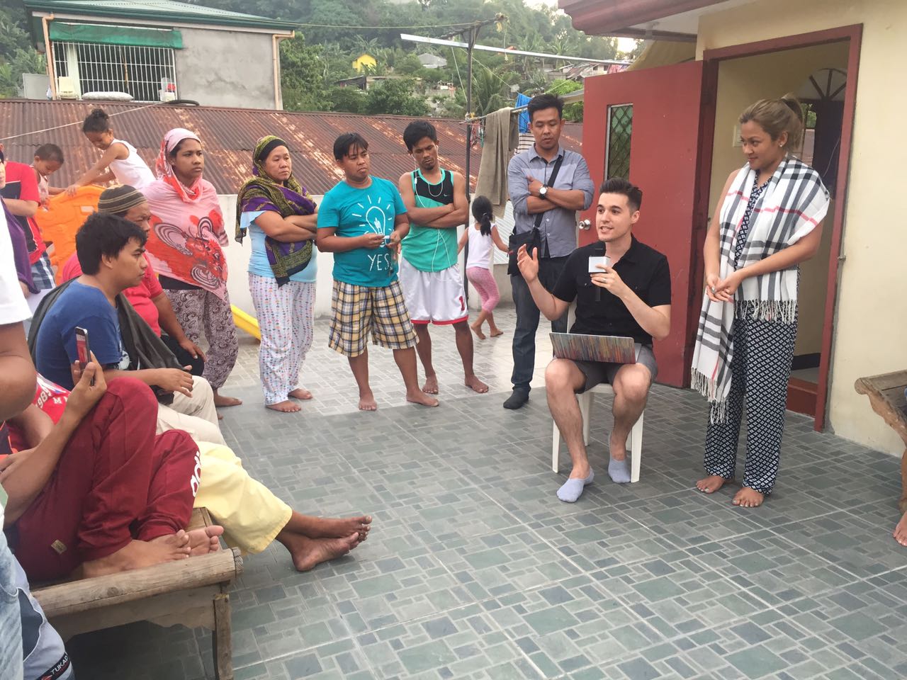 On the roof of a mosque in the Philippines, David Webber, assistant professor of homeland security and emergency preparedness and assistant program chair, explains his research to survey participants.