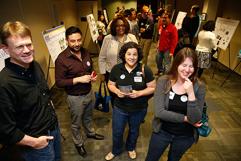 Faculty, students and guests view the posters in between rounds.