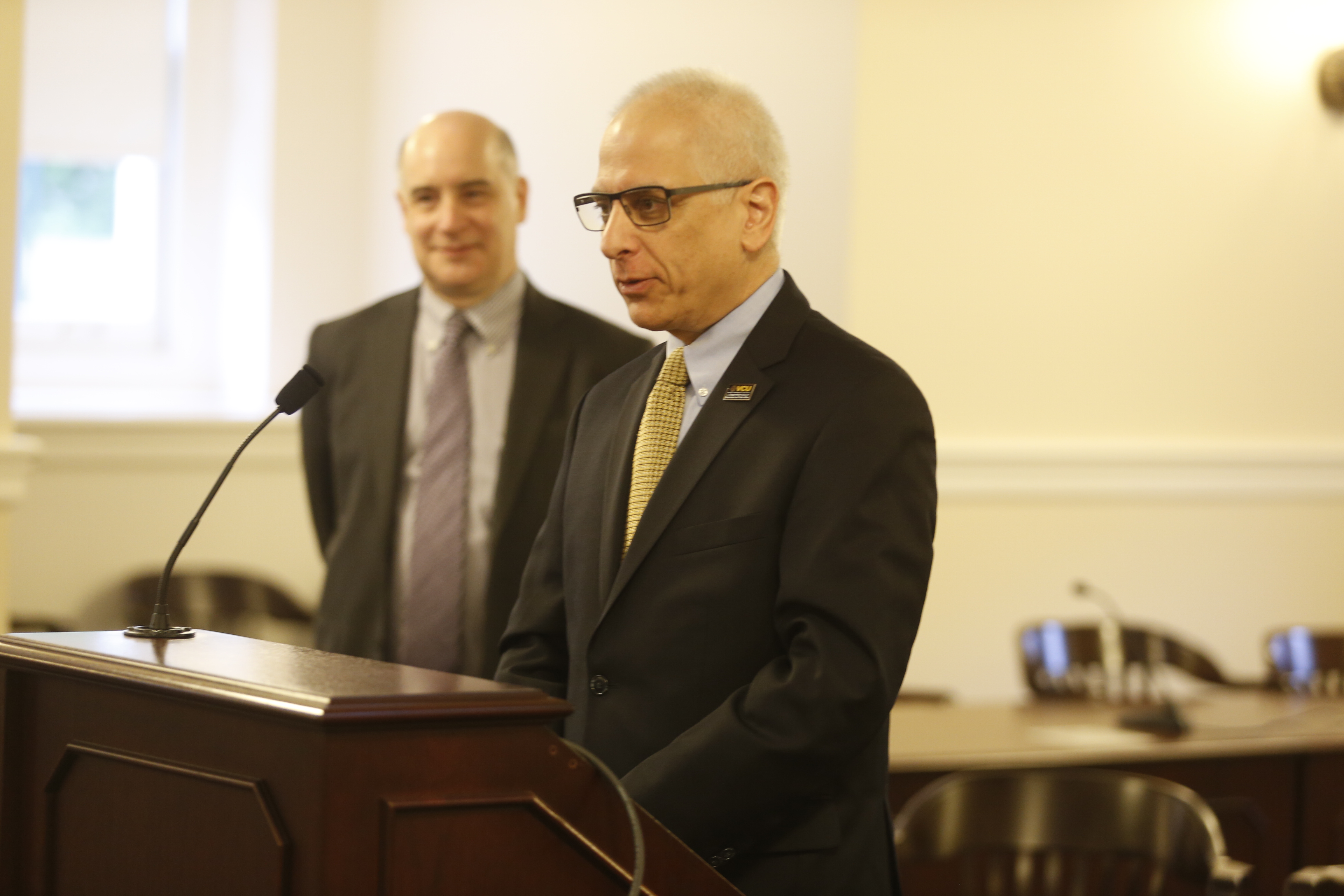 Wilder School Dean John Accordino, Ph.D., addresses the May 5 graduation, as  PMG Director James Burke listens.